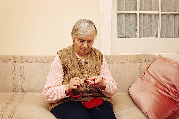 istock Elderly woman knitting with red wool 465117368