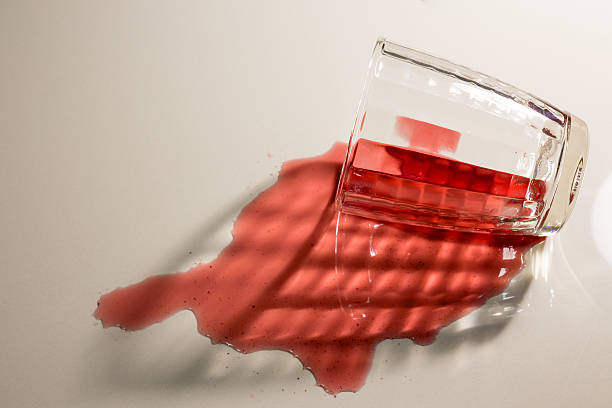 a glass of red wine on a white background with a play of shadows, top view