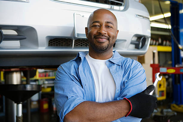 istock Confident Mechanic Holding Wrench At Garage 465120592