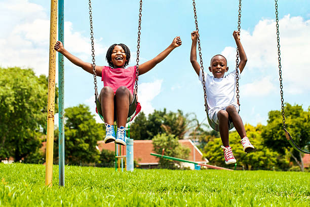 중유럽식 kids 게임하기 on 흔들리다 in 이웃이란. - child swinging playground african descent 뉴스 사진 이미지