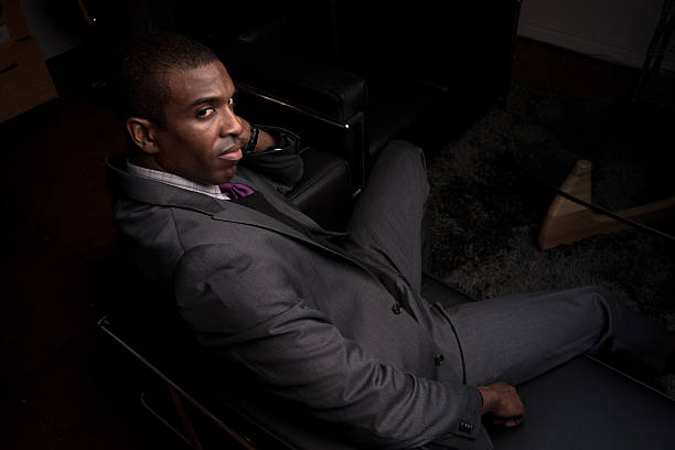 istock Intense Man in Suit Sitting in Darkened Room 465124834