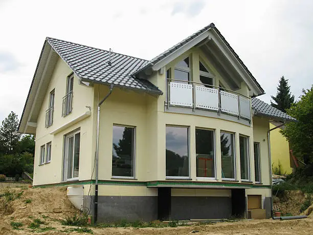 View onto the glass front of a newly constructed yellow single-family house.