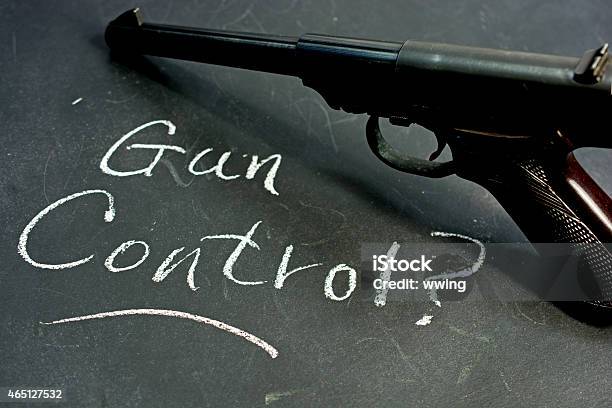 Gun Control Question On A Blackboard With Automatic Pistol Stock Photo - Download Image Now