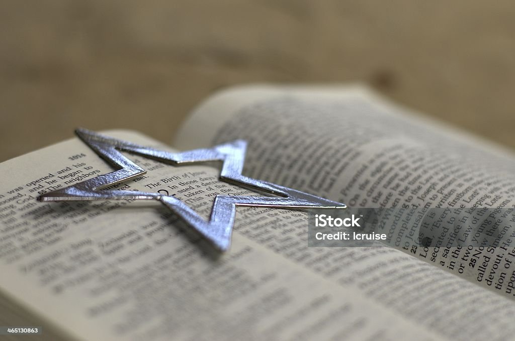 Luke 2 with silver star Bible open to Luke, Chapter 2 with silver star ornament surrounding the words, "The Birth of Jesus" Bible Stock Photo