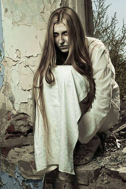 istock zombie girl sitting in abandoned building 465134114