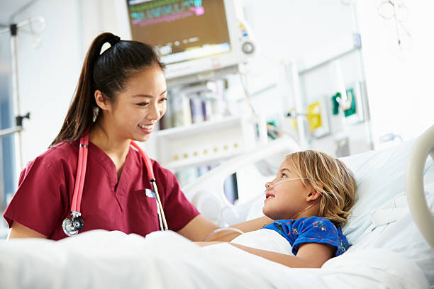 Young Girl Talking To Female Nurse In Intensive Care Unit Young Girl Talking To Happy Smiling Female Nurse In Intensive Care Unit intensive care unit photos stock pictures, royalty-free photos & images