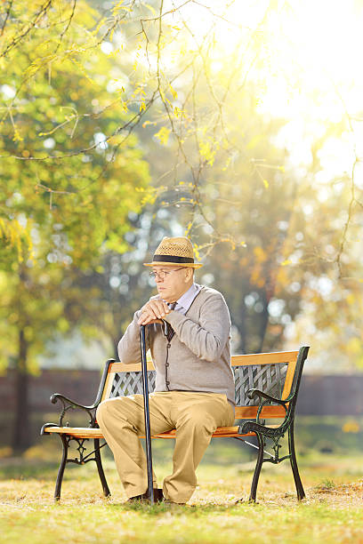 istock Sad senior gentleman with a cane sitting in park 465136547