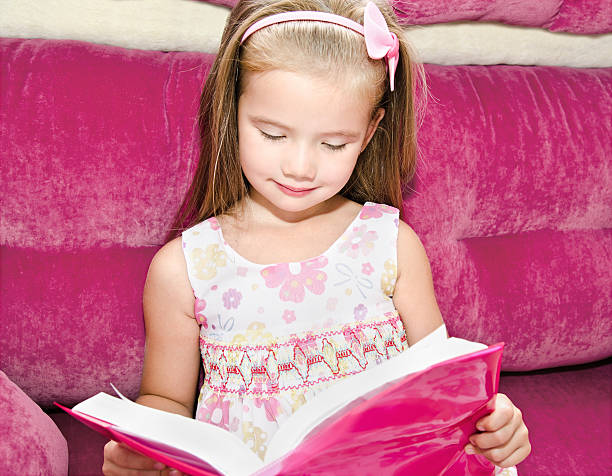 istock Cute little girl reading a book 465136845