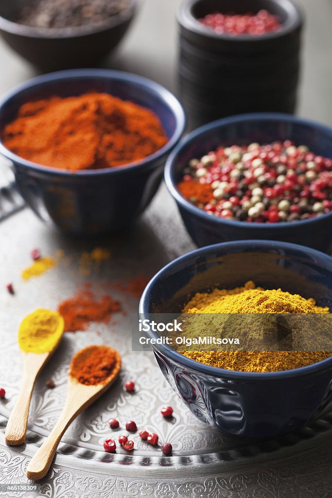 spices in bowls: curry, pink and black pepper, paprika powder Black Color Stock Photo