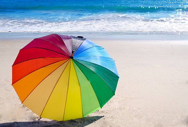 istock Rainbow umbrella by the ocean 465138458