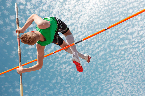 Young athletes pole vault seems to reach the sky