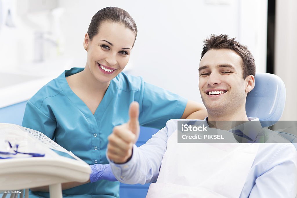 Man giving thumbs up at dentist office Patient Stock Photo