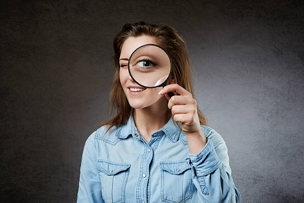 istock Cheerful woman looking through magnifying glass 465140260