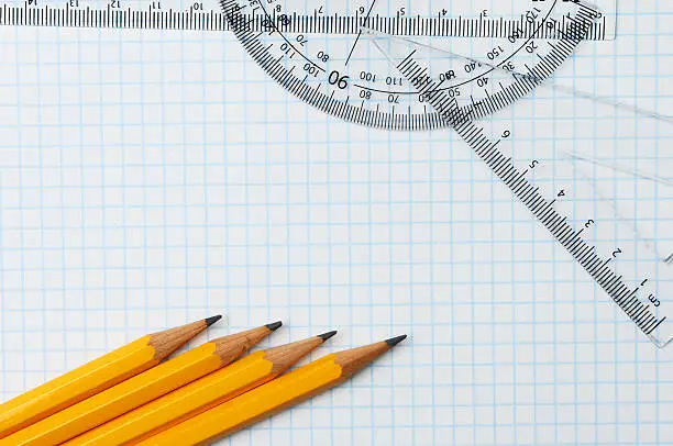 Pencils, rule,protractor and set square on graph paper