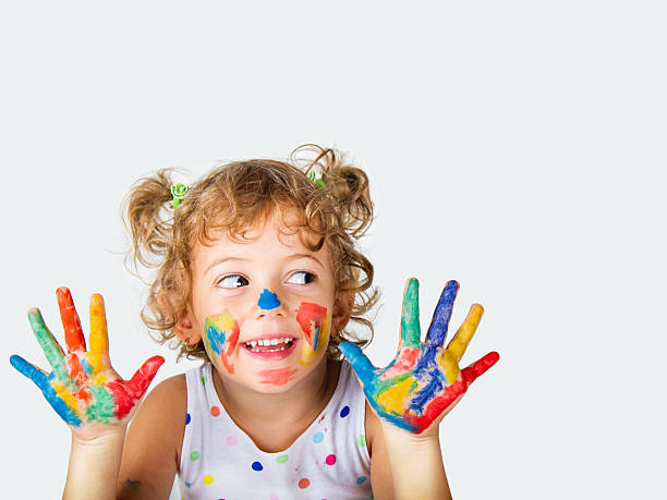 Young girl with paint on her hands and face stock photo