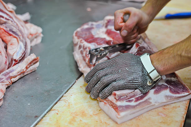Close-up of worker manually processing meat