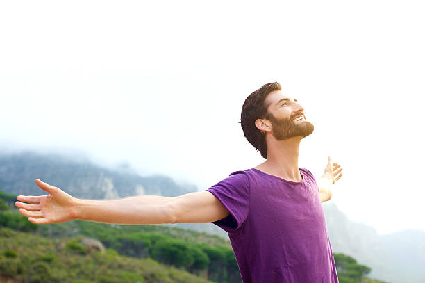 istock Happy young man standing in nature with arms spread open 465143702