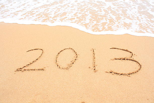 2013 schriftliche in sand und wellen - 2013 beach new years eve new years day stock-fotos und bilder