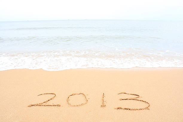 2013 schriftliche in sand und wellen - 2013 beach new years eve new years day stock-fotos und bilder