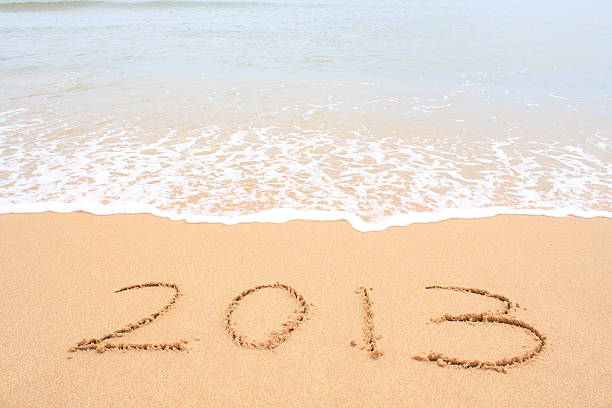 2013 schriftliche in sand und wellen - 2013 beach new years eve new years day stock-fotos und bilder