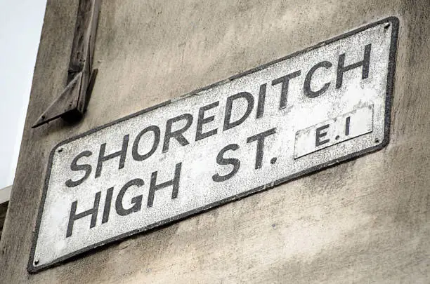 Road sign for Shoreditch High Street, a fashionable street full of cafes and shops popular with hipsters in the Hackney district of London.