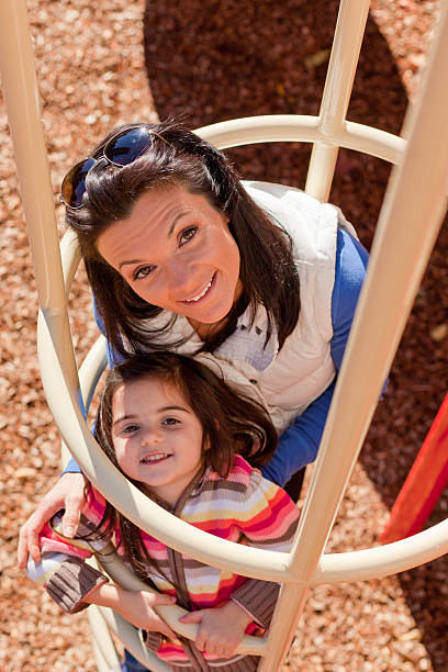 Mom and daughter playing on jungle gym 7 stock photo