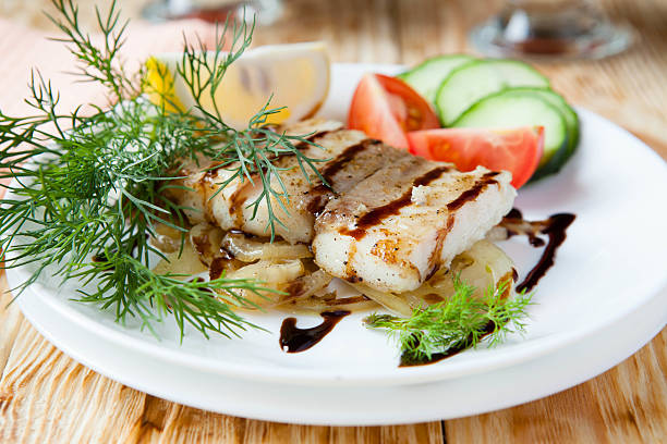 fish on a pillow with onion sauce and vegetables, close up food