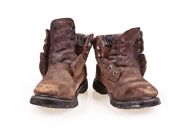 istock Dirty old boots isolated over white background 465147091