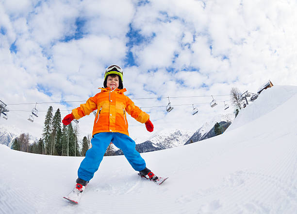 istock Boy with mask and helmet skiing on ski resort 465150134