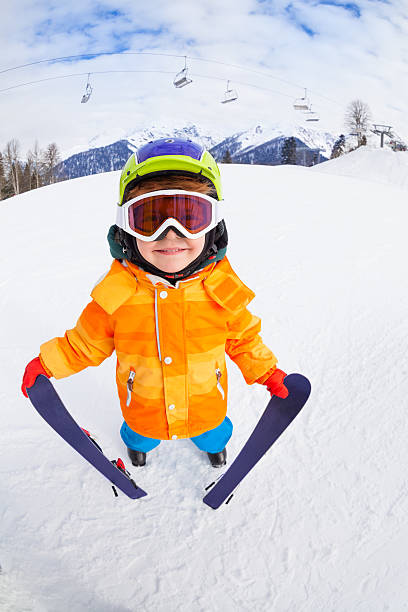 istock Smiling boy wearing mask holds ski in mountains 465150214