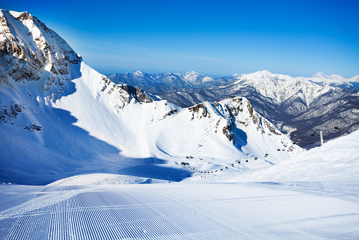 Ski-track view with Caucasus mountains on background during daytime in Sochi ski resort Krasnaya polyana