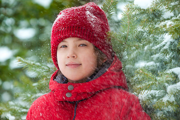 istock Happy boy with falling snow in the forest 465153686
