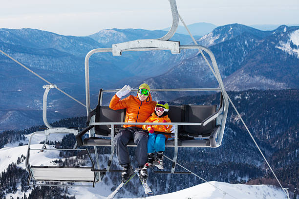 istock Man skier with child lift on ropeway chair 465153696