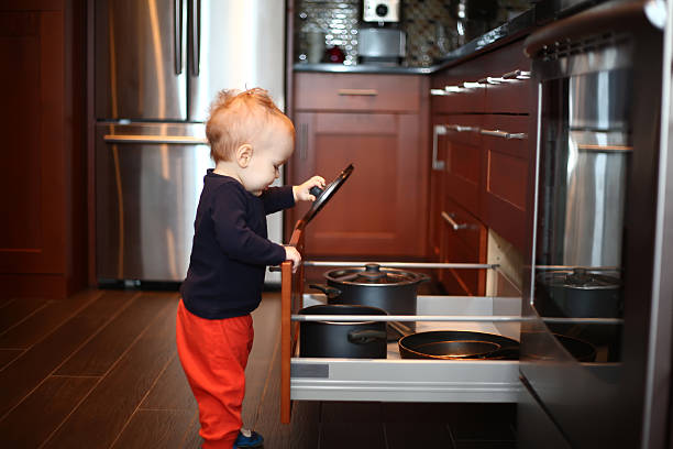 istock Baby playing with cookware in the kitchen drawer 465154984