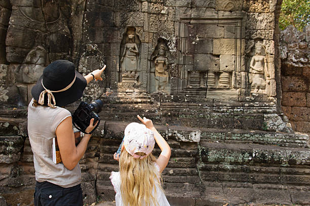Mother And Daughter Looking At Ancient Temple Rear view of mother and daughter pointing while looking at ancient temple angkor thom stock pictures, royalty-free photos & images