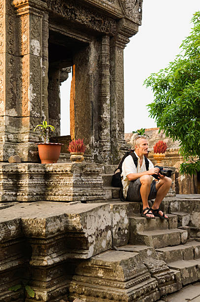 istock Man With Digital Camera Sitting On Steps Of Ancient Temple 465155098