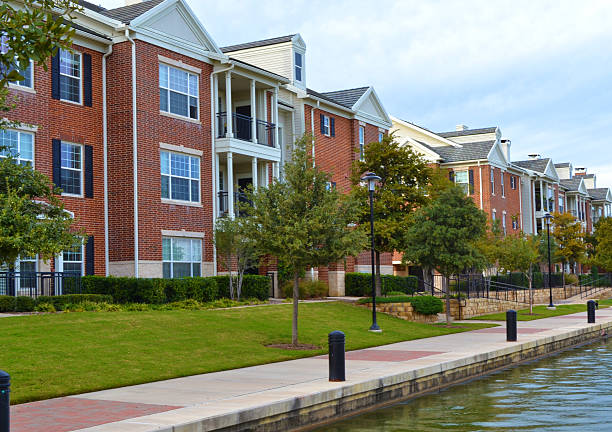 Townhouses A row of townhouses with blue sky and water next to walkway. image created 21st century blue architecture wide angle lens stock pictures, royalty-free photos & images