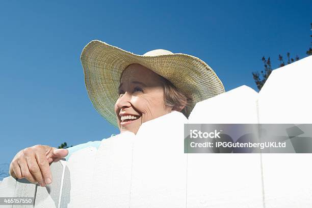 Photo libre de droit de Clôture Femme Donnant Sur Le Jardin banque d'images et plus d'images libres de droit de Voisin - Voisin, Indiscret, Clôture