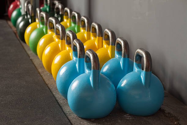 colorful kettlebells in a row in a gym stock photo
