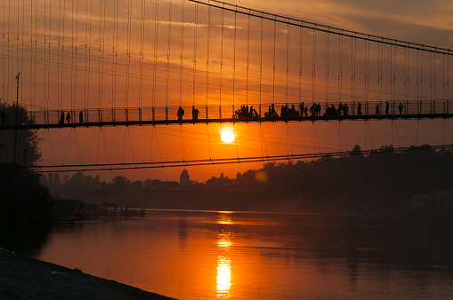 View of River Ganga and Ram Jhula bridge at sunset. Rishikesh. India