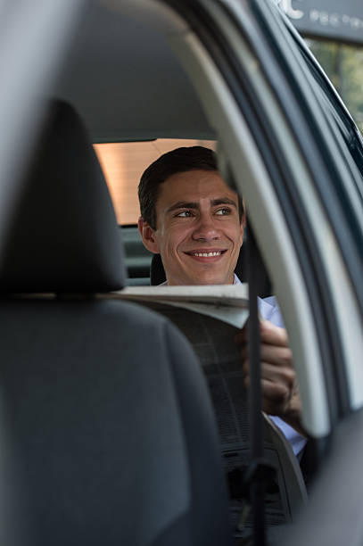 istock Businessman reading newspaper car 465159478