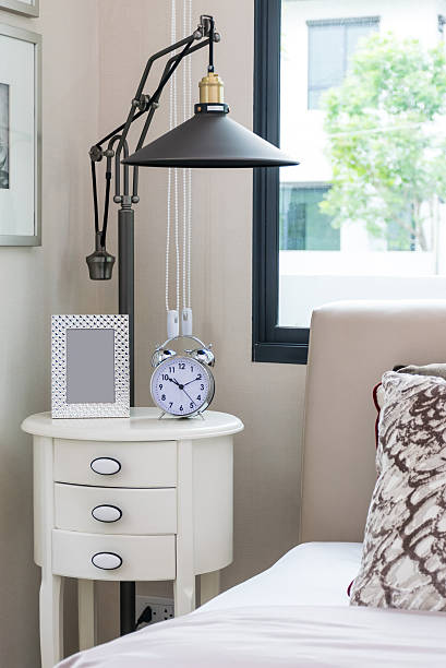 istock black lamp, picture frame and alarm clock on bedside table 465159548
