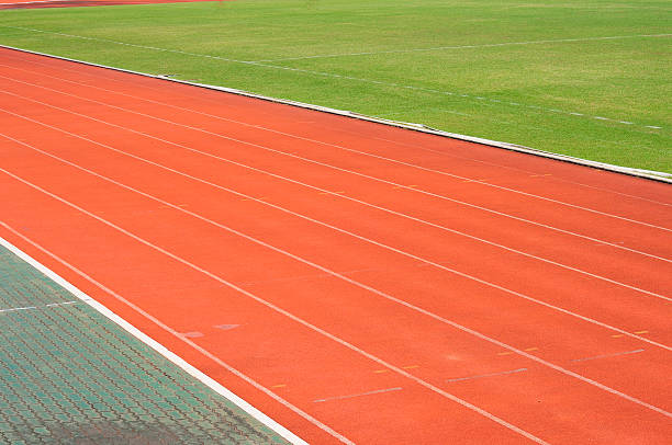 istock Orange racecourse with white line and green yard 465159859