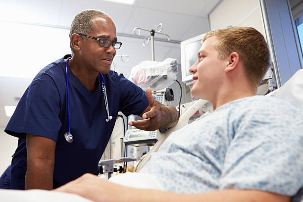 jovem paciente falando de enfermeiro de emergência no quarto - hospital patient bed nurse - fotografias e filmes do acervo