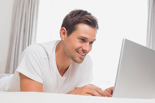 istock Relaxed casual man using laptop in bed 465160690