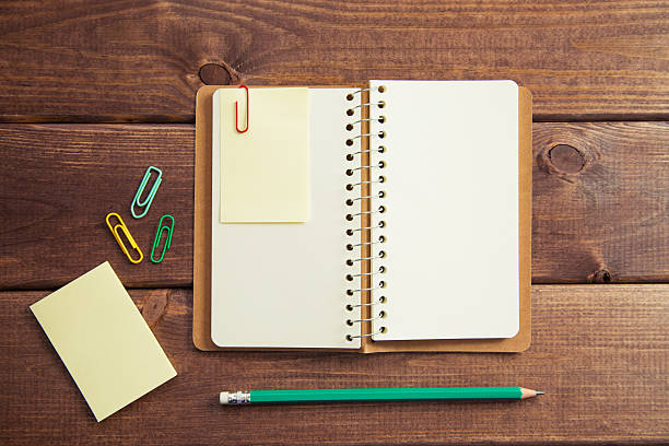 Open sketchbook and a pencil (notebook) on the wooden table. Toned image, taken with Canon 5D MkIII