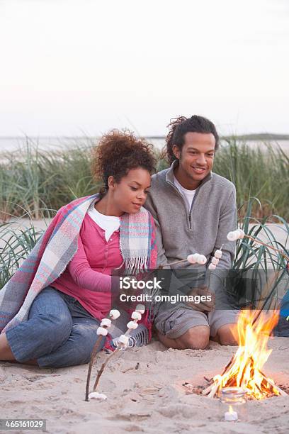 Couple Camping On Beach And Toasting Marshmallows Stock Photo - Download Image Now - Camping, Women, 20-29 Years