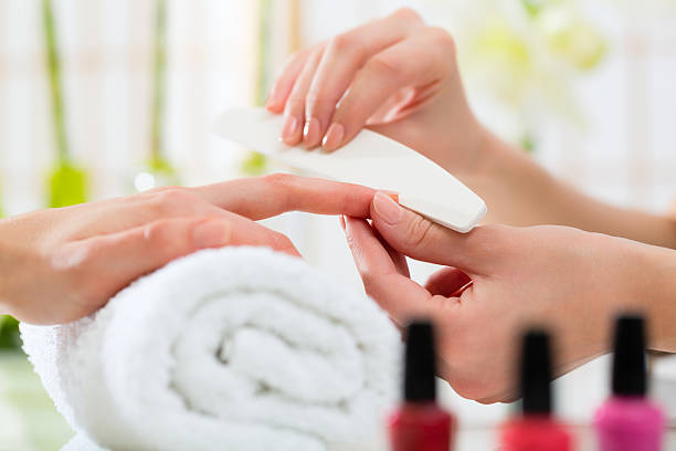 istock Woman in nail salon receiving manicure 465161237