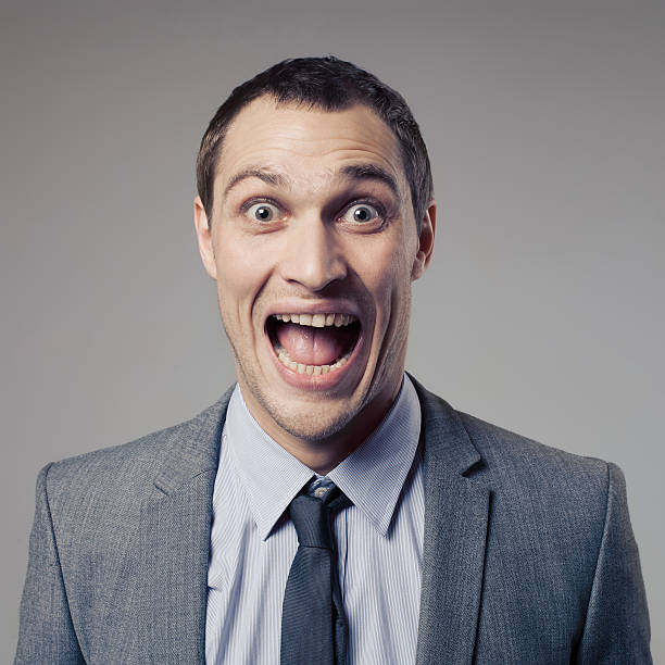 istock Excited businessman in a suit screaming on a gray background 465164249