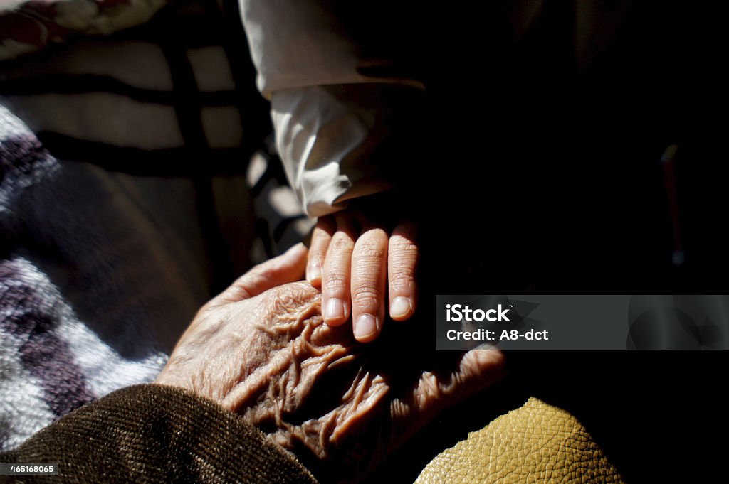 holding hand with grandfather image of a young girl holding hand with her grandfather of 90 years old Grandchild Stock Photo